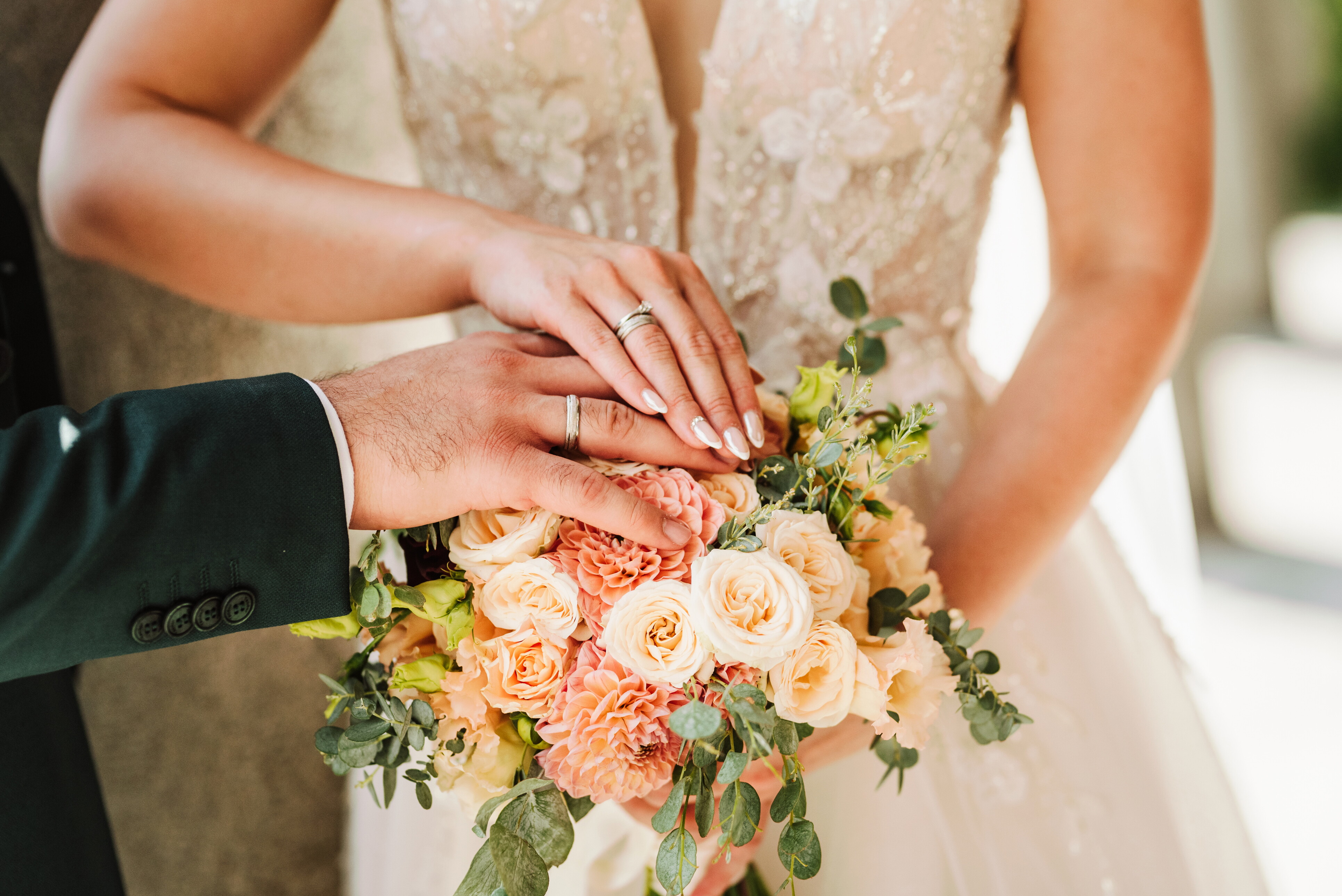 Weddings at the John Carver Inn & Spa - Bride and Groom Holding Hands on a Bouquet
