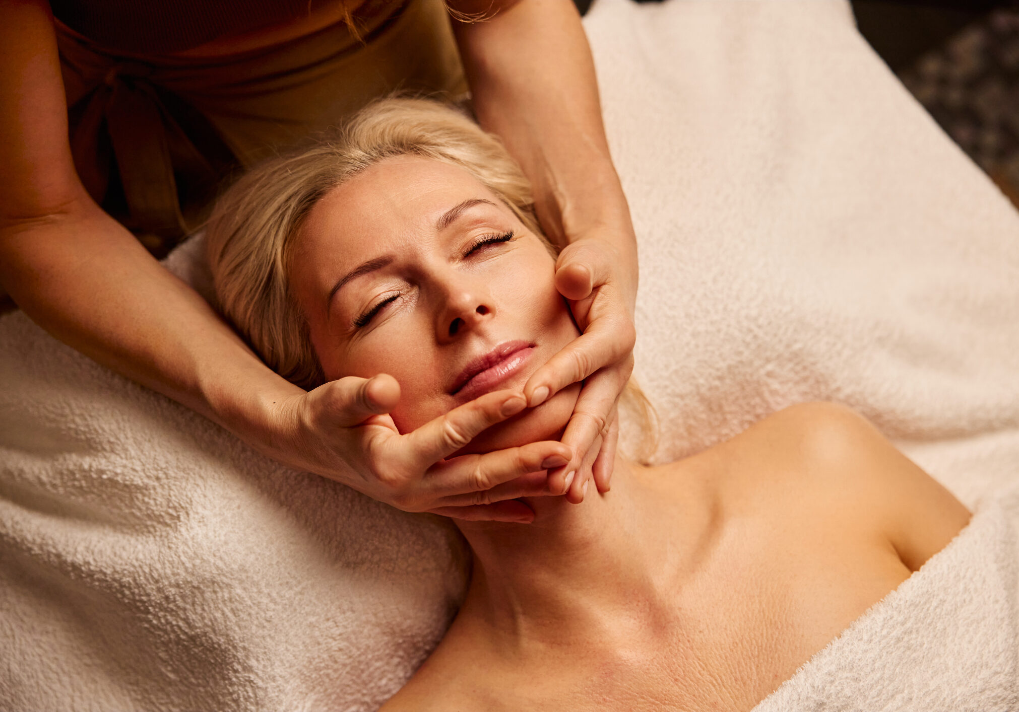 Serene Spa Experience with Relaxing Facial Massage. A woman enjoys a calming spa treatment with a gentle facial massage